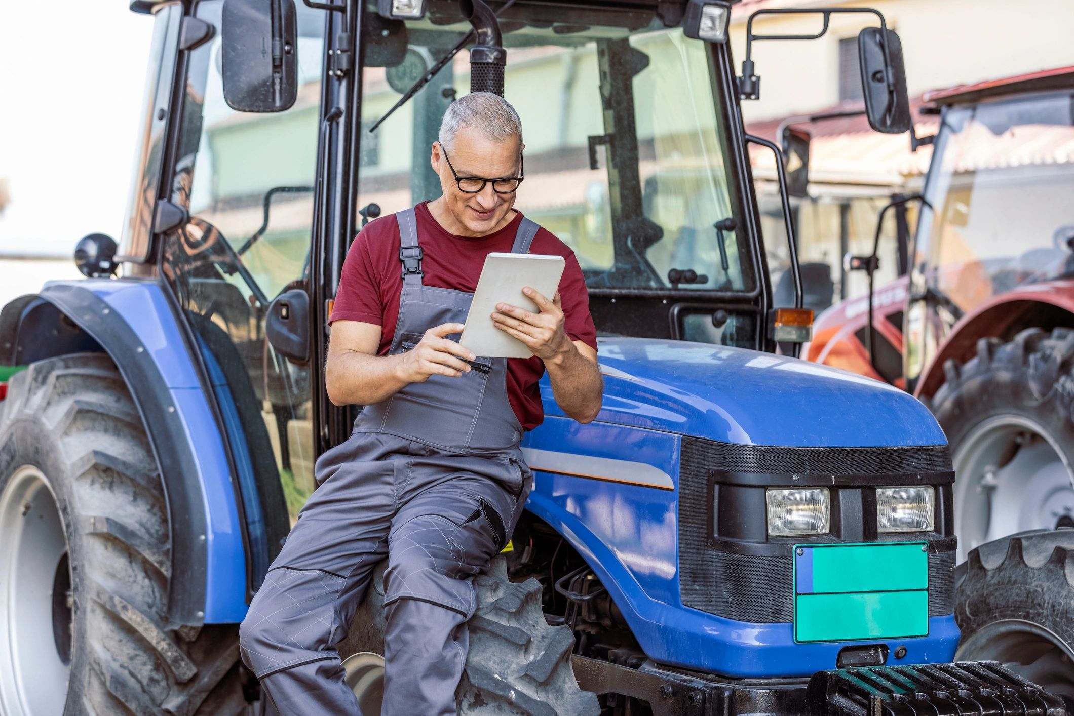 Farmer using a tablet while sitting on a tractor