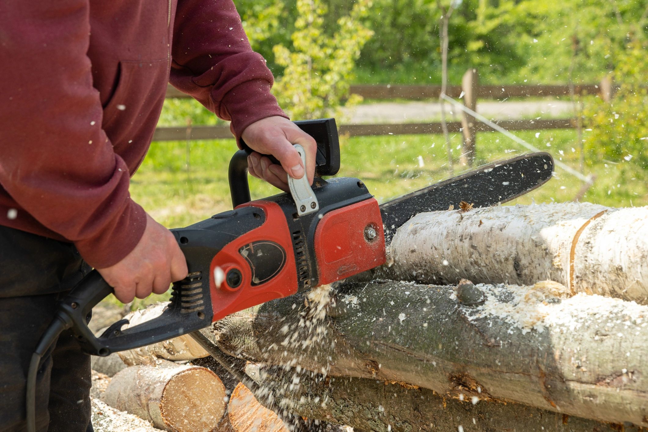 Person cutting firewood with a chainsaw