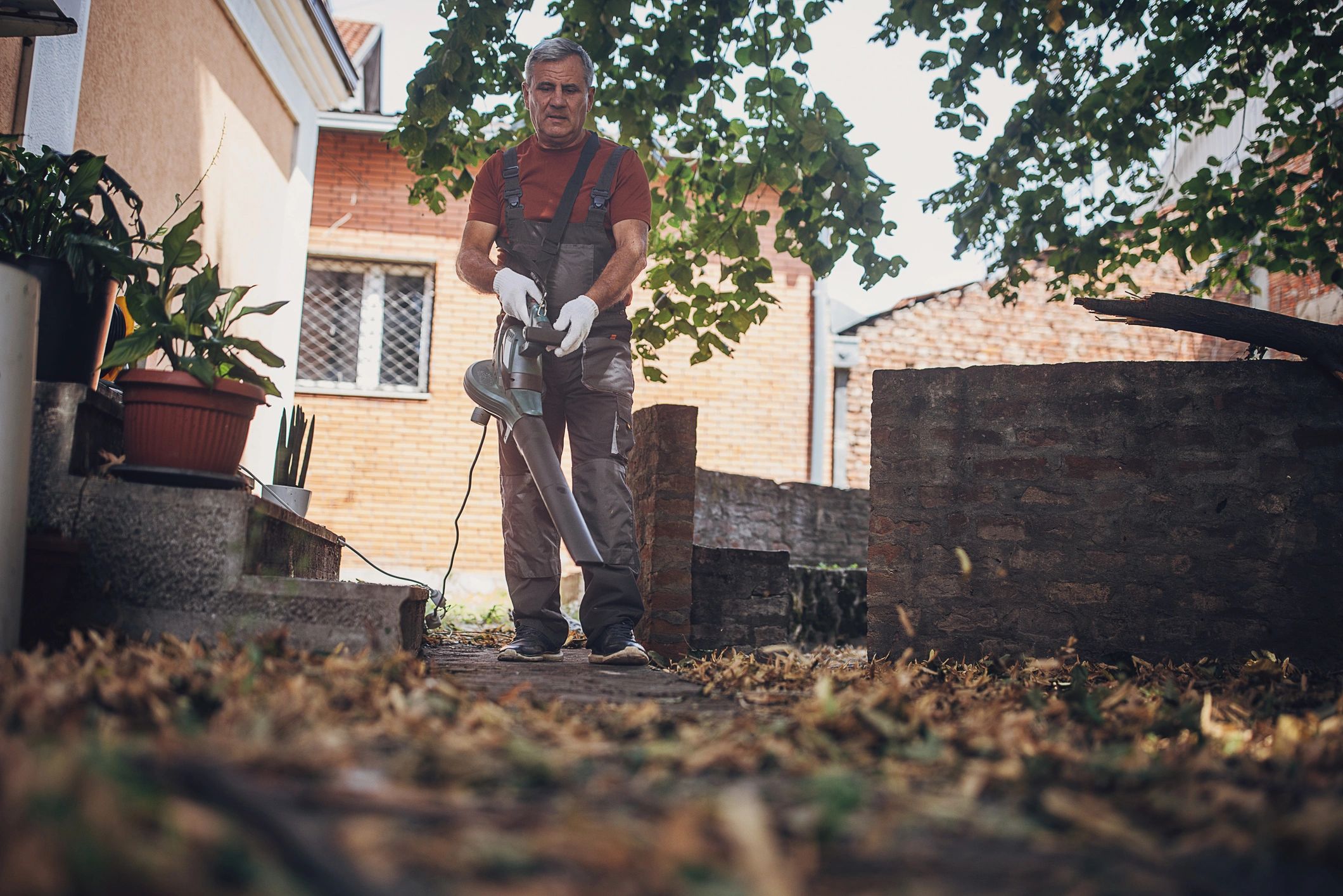 Man using a leaf blower to clean a yard