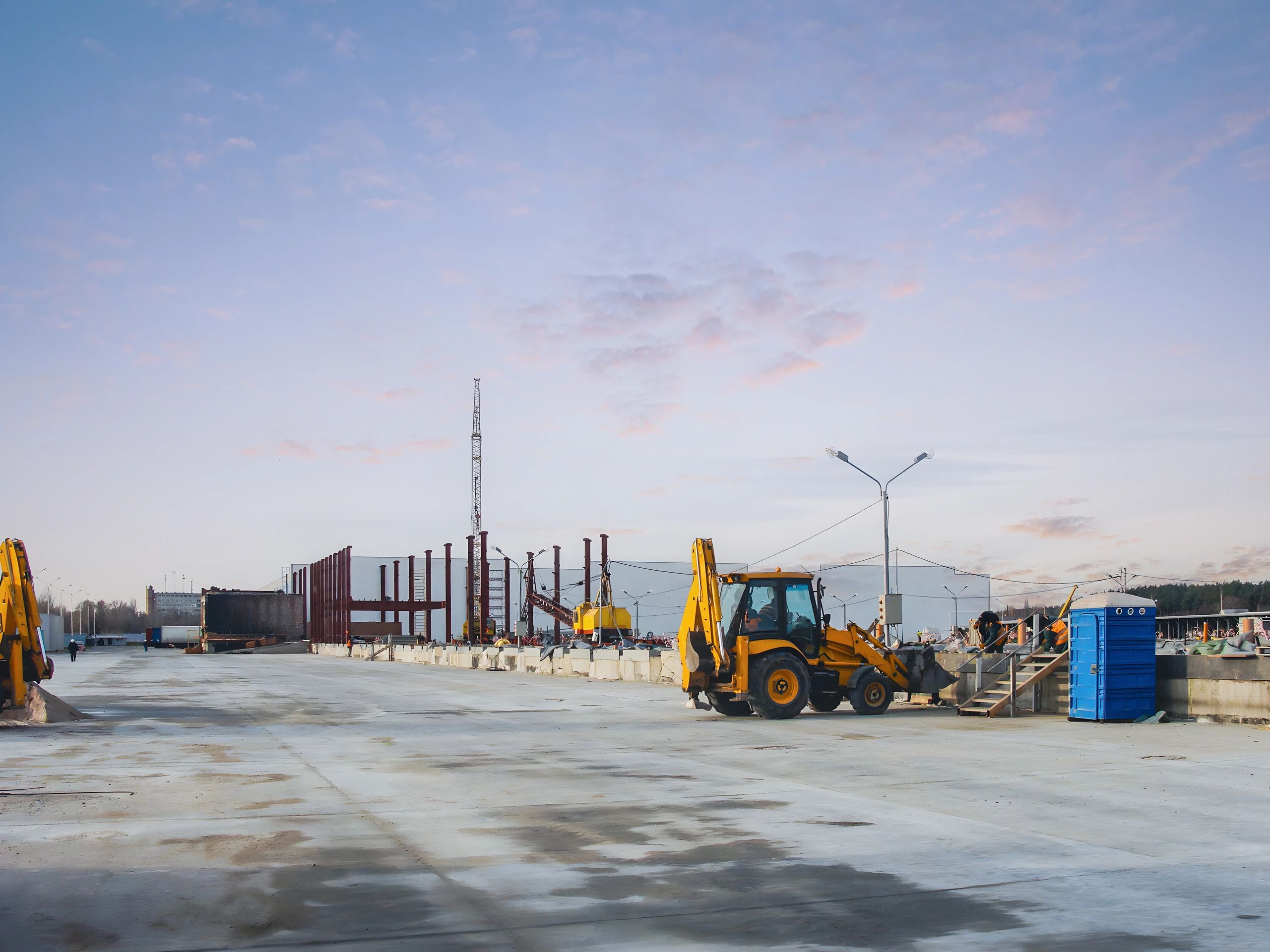 Construction site with heavy machinery under a cloudy sky